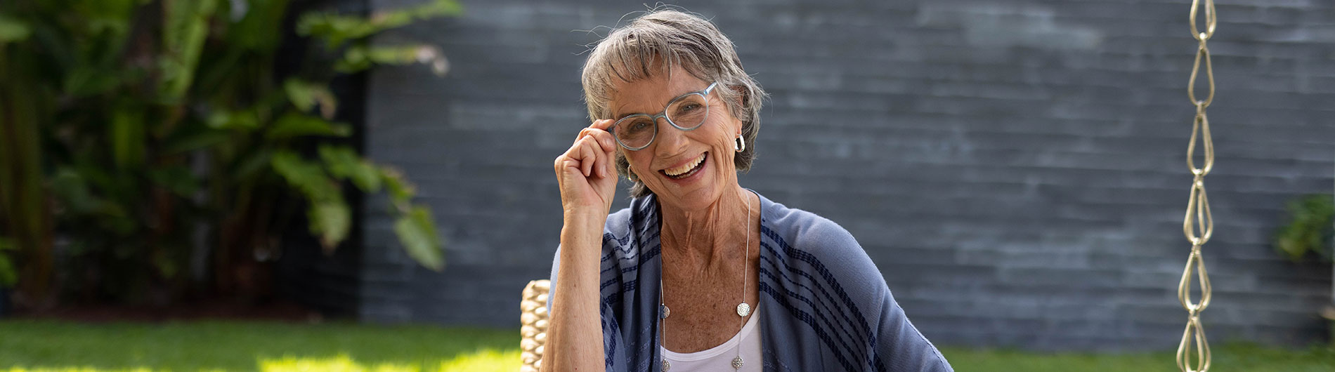 Older woman smiling and showing off her eyeglasses